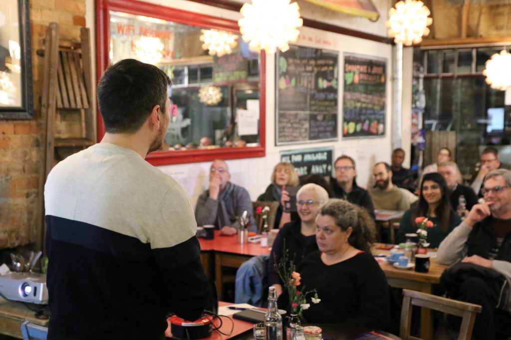 A speaker addressing a public audience at a Cafe Sci event
