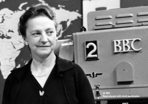 A black and white image of a women in front of a BBC camera